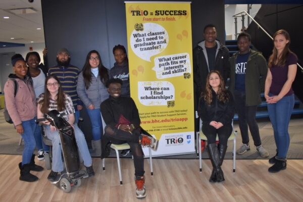 Trio students gathered around a banner